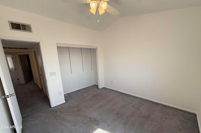 unfurnished bedroom featuring dark carpet, ceiling fan, vaulted ceiling, and a closet