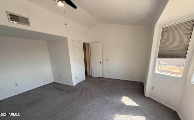 empty room with lofted ceiling, ceiling fan, and dark colored carpet