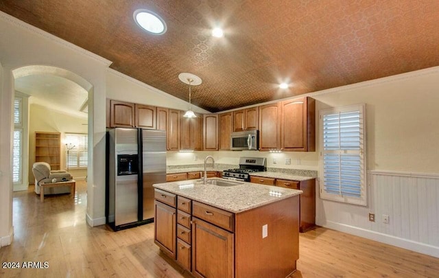 kitchen with sink, stainless steel appliances, an island with sink, pendant lighting, and vaulted ceiling