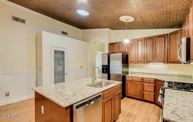 kitchen with a center island with sink, light stone countertops, hanging light fixtures, and appliances with stainless steel finishes