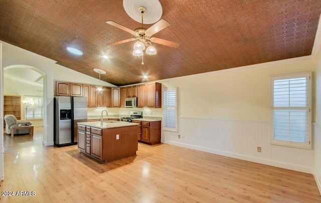 kitchen with a center island with sink, stainless steel appliances, vaulted ceiling, and light hardwood / wood-style flooring