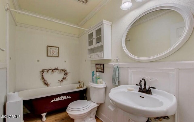 bathroom with ornamental molding, sink, a bath, hardwood / wood-style flooring, and toilet