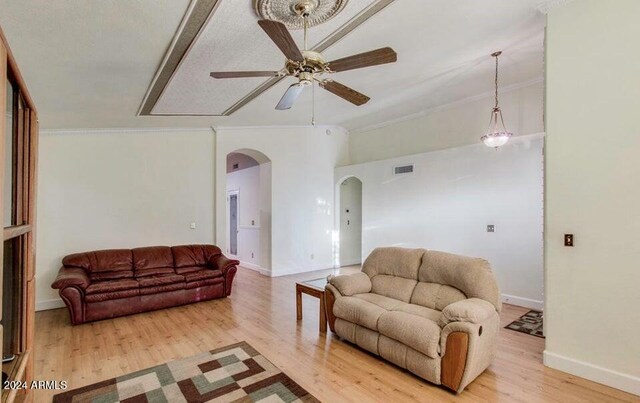 living room with hardwood / wood-style floors, ceiling fan, and ornamental molding