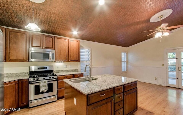 kitchen featuring stainless steel appliances, a kitchen island with sink, crown molding, sink, and decorative light fixtures