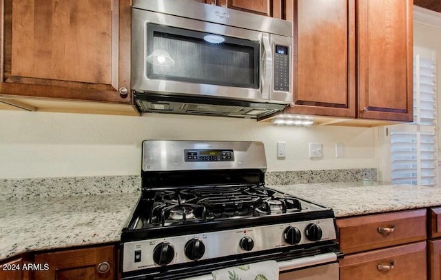 kitchen with light stone countertops and stainless steel appliances