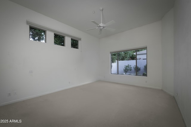 carpeted spare room with ceiling fan