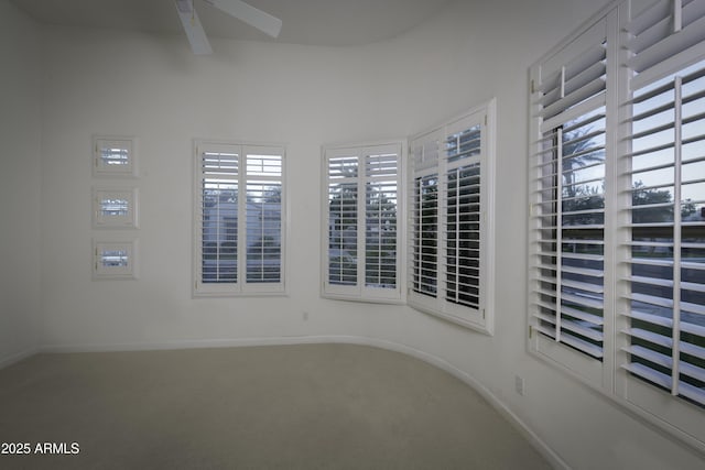 empty room with ceiling fan and carpet flooring