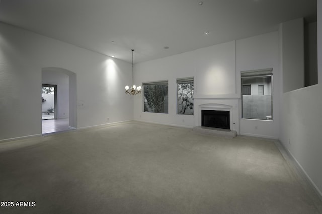 unfurnished living room featuring light colored carpet and an inviting chandelier