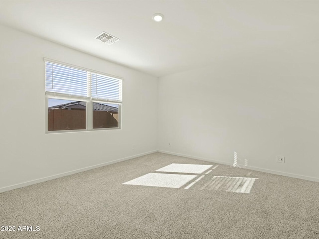 empty room with carpet, visible vents, and baseboards