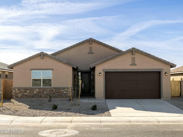 ranch-style home featuring stucco siding, driveway, an attached garage, and fence