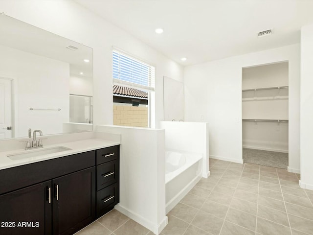 full bath with visible vents, recessed lighting, baseboards, a bath, and vanity