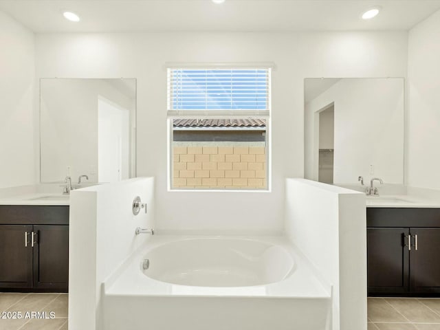 bathroom featuring tile patterned flooring, vanity, and a bath