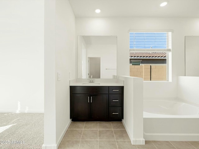 bathroom with recessed lighting, a bath, vanity, and tile patterned flooring