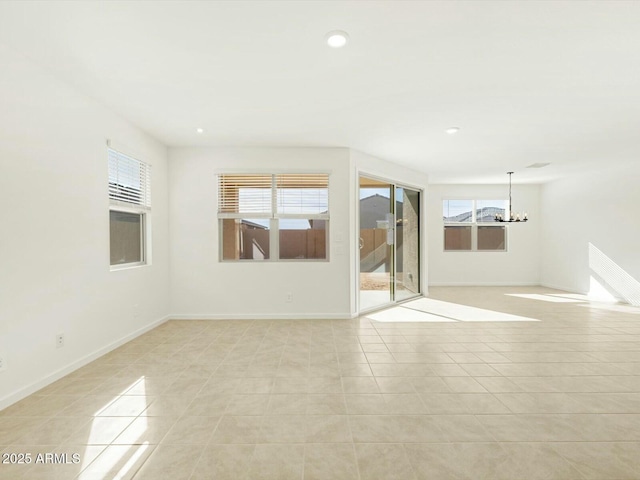 spare room featuring light tile patterned floors, recessed lighting, baseboards, and a wealth of natural light