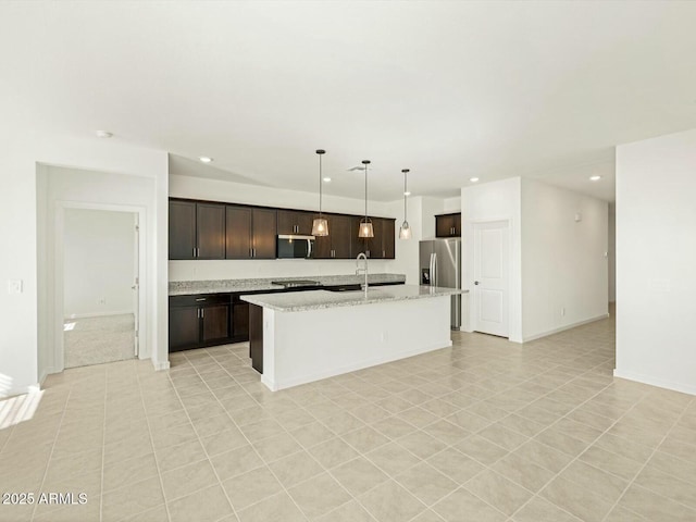 kitchen featuring recessed lighting, stainless steel appliances, dark brown cabinetry, and an island with sink