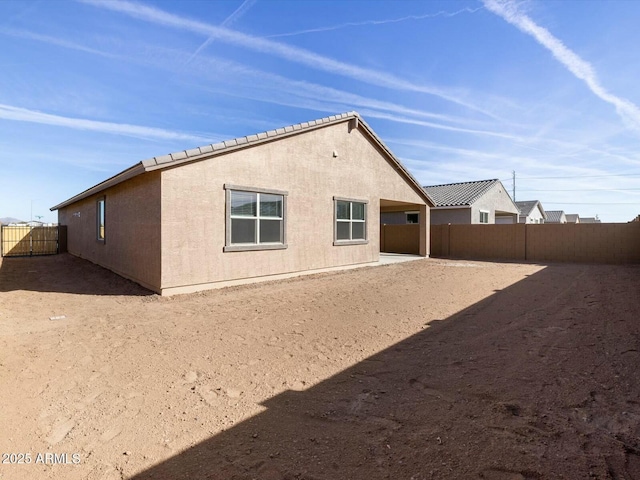 rear view of property featuring stucco siding and a fenced backyard