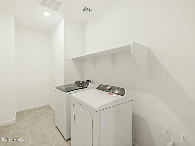 clothes washing area featuring visible vents, baseboards, laundry area, and washer and clothes dryer