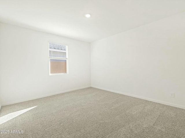 carpeted spare room with baseboards