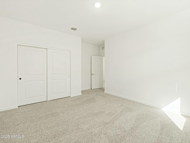 unfurnished bedroom featuring visible vents, baseboards, a closet, and carpet flooring