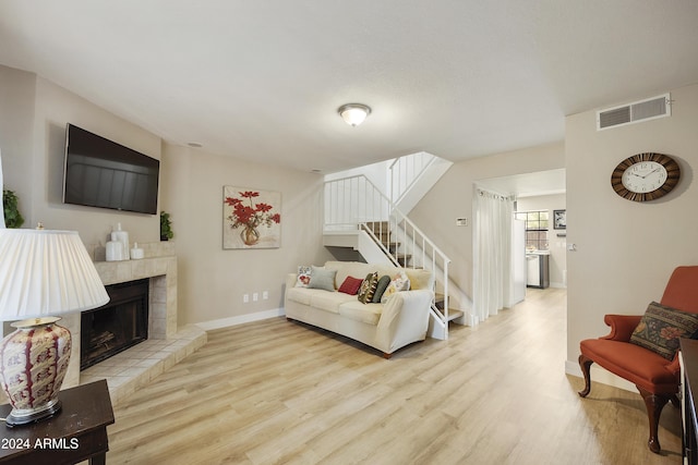 4901 E Kelton Ln Unit 1006, Scottsdale, AZ 85254 - living room featuring wood finished floors, a tile fireplace, and stairway
