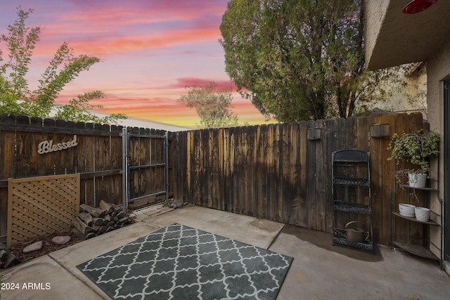 4901 E Kelton Ln Unit 1006, Scottsdale, AZ 85254 - patio terrace at dusk with a patio, a gate, and a fenced backyard