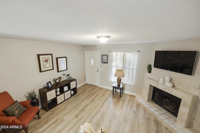 4901 E Kelton Ln Unit 1006, Scottsdale, AZ 85254 - living room with wood finished floors, a tile fireplace, and a textured ceiling