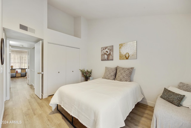 4901 E Kelton Ln Unit 1006, Scottsdale, AZ 85254 - bedroom featuring light wood-style flooring, a towering ceiling, and a closet