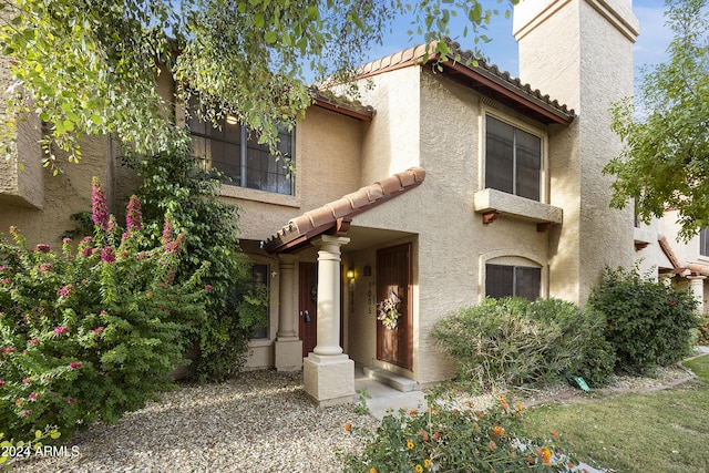 4901 E Kelton Ln Unit 1006, Scottsdale, AZ 85254 - view of front of home with stucco siding, a tile roof, and a chimney