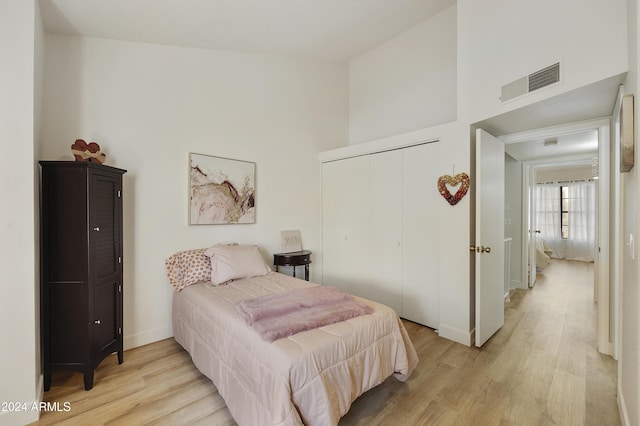 4901 E Kelton Ln Unit 1006, Scottsdale, AZ 85254 - bedroom featuring light wood-style flooring, a closet, and a towering ceiling