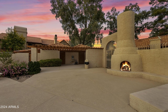 4901 E Kelton Ln Unit 1006, Scottsdale, AZ 85254 - view of front of house with a warm lit fireplace, a patio, stucco siding, and a tile roof