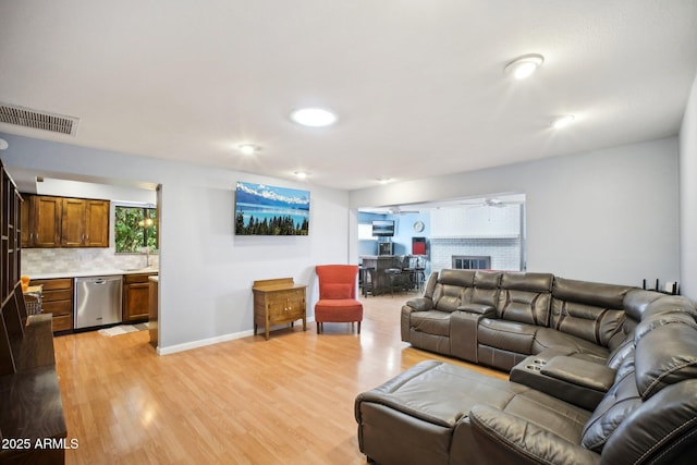 living room with ceiling fan and light hardwood / wood-style flooring