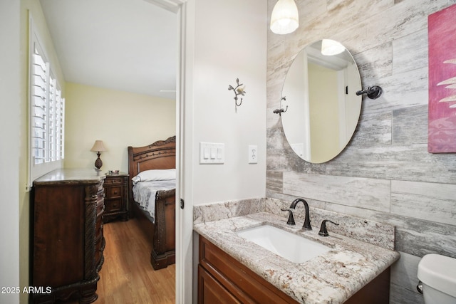 bathroom featuring toilet, wood-type flooring, vanity, and a wealth of natural light