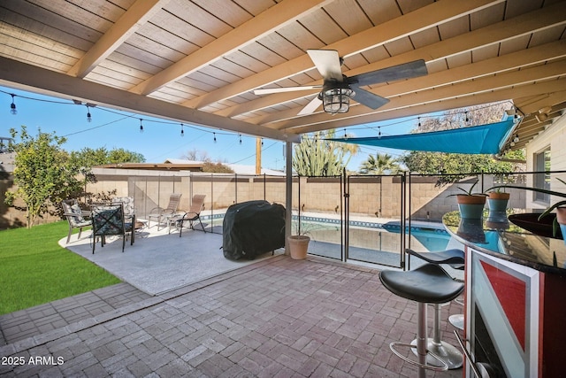 view of patio with grilling area, exterior bar, and a fenced in pool