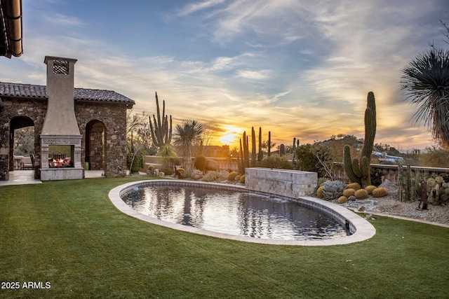 27256 N 97th Pl, Scottsdale, AZ 85262 - pool at dusk with a lawn and an outdoor fireplace