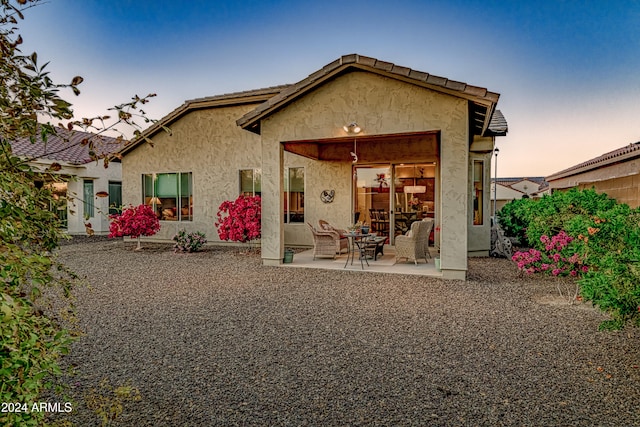 back house at dusk with a patio