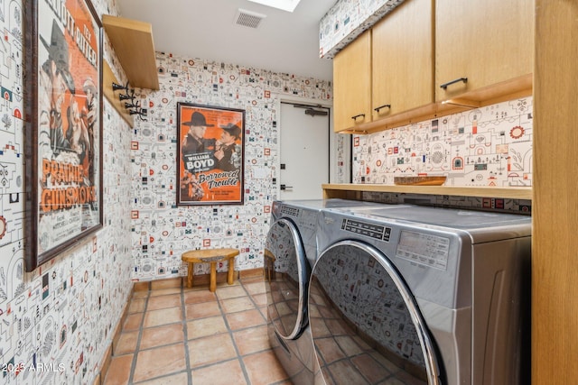 laundry room featuring cabinets, separate washer and dryer, and light tile patterned floors