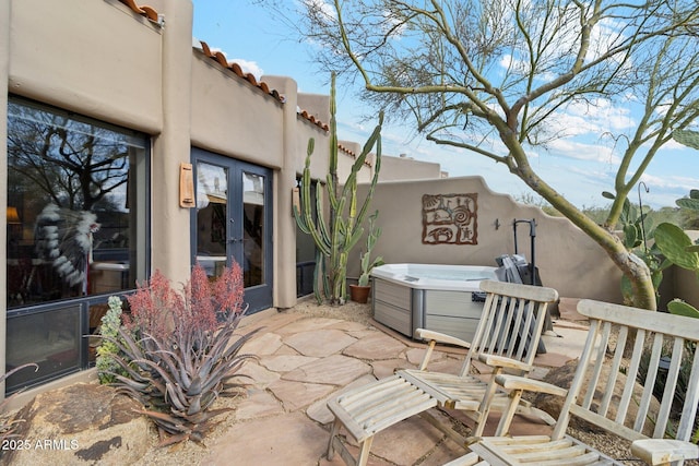 view of patio / terrace featuring french doors and a hot tub