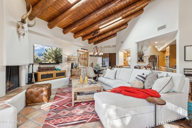 living room with a high ceiling, light tile patterned floors, beamed ceiling, a notable chandelier, and wood ceiling