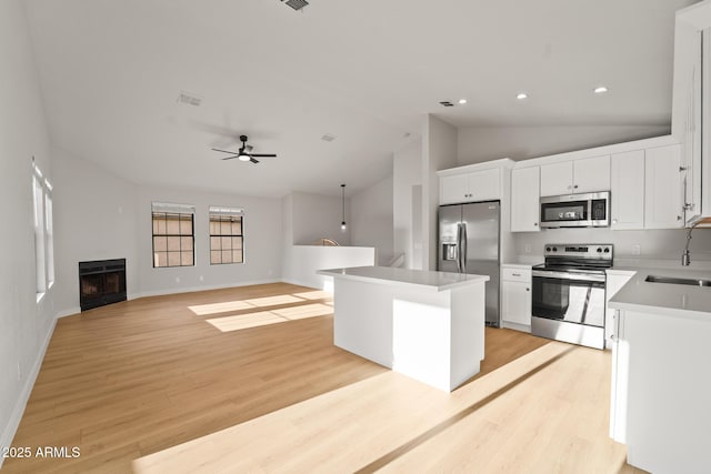 kitchen with light wood-type flooring, a sink, ceiling fan, and stainless steel appliances