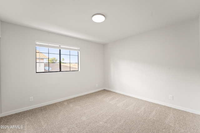 empty room featuring carpet floors and baseboards