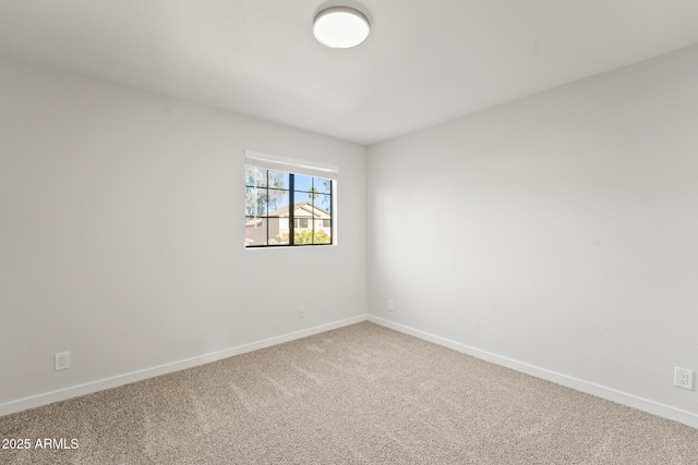 carpeted spare room featuring baseboards
