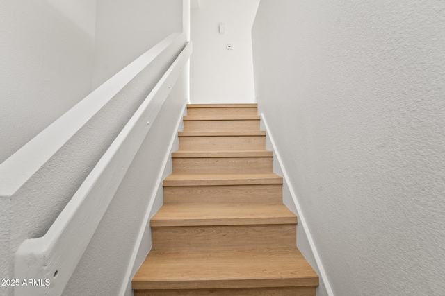 staircase featuring a textured wall