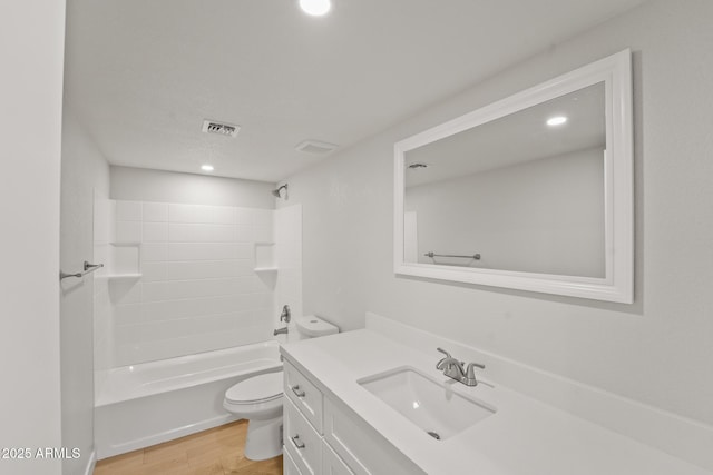 bathroom with visible vents, vanity, wood finished floors, toilet, and shower / bathing tub combination