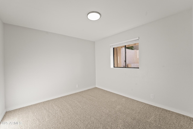 unfurnished room with carpet flooring and baseboards
