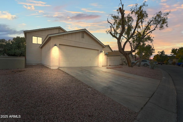 ranch-style house with board and batten siding, fence, driveway, and a garage