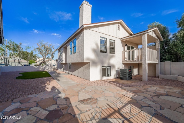 back of house with a fenced backyard, a patio, a chimney, and a balcony