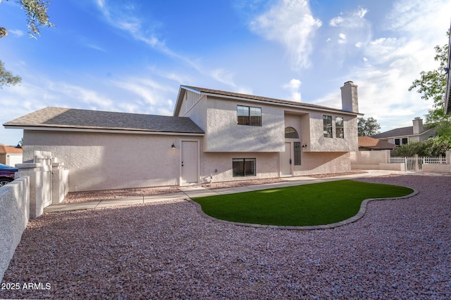 back of property with fence, stucco siding, a chimney, and a patio area