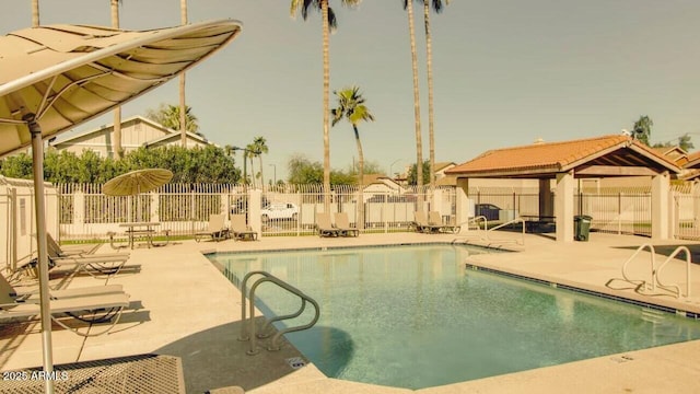 community pool featuring a gazebo, fence, and a patio area