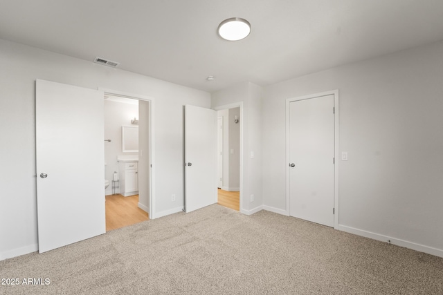 unfurnished bedroom featuring visible vents, connected bathroom, baseboards, and light carpet