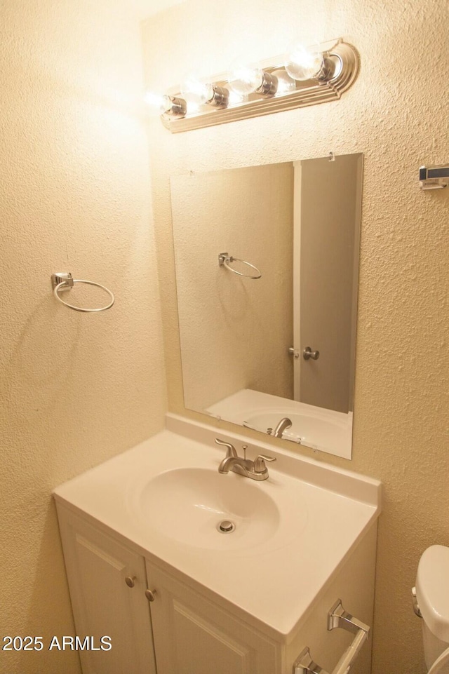 bathroom featuring vanity and toilet